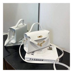 Detail view of white lychee pattern PU leather bag with gold-tone metal twist lock closure
