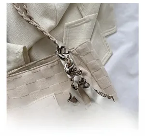 Close-up of silk scarf with vintage chain pattern tied to a beige canvas tote bag