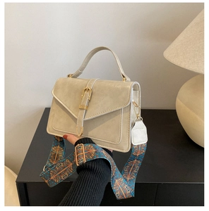 Detail of retro cream crossbody bag with gold buckle and ethnic patterned wide strap