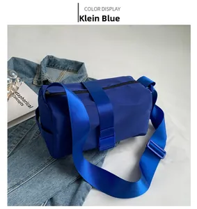 Detail of Klein blue oxford crossbody bag showing strap buckle and nylon fabric texture