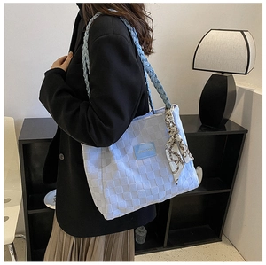 Detail of blue woven canvas tote bag featuring a leather patch and patterned silk scarf