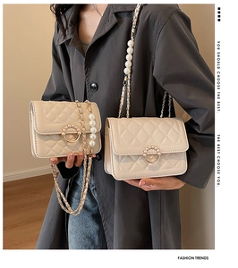 Detail of white quilted crossbody bags with pearl chain and elegant metal ring buckle