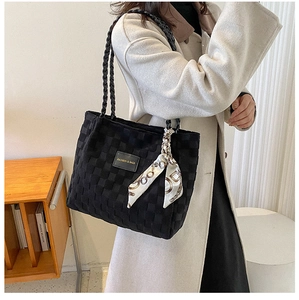 Detail of black woven tote bag with Fashion & Bags logo and elegant silk scarf accessory