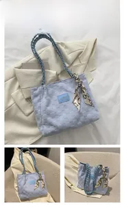 Blue canvas tote bag with woven texture, fashion badge and silk scarf detail
