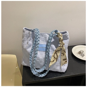 Detail of light blue woven tote bag with silk scarf and FASHION & BAGS leather patch