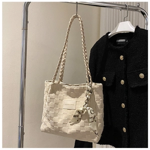 Close-up of cream canvas tote bag with woven texture and a printed silk scarf handle