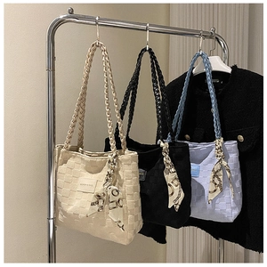 Detail of woven lattice tote bags with patterned silk scarves in beige, black, and blue