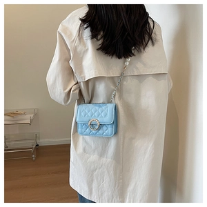 Detail of light blue quilted mini crossbody bag with pearl chain and ring buckle