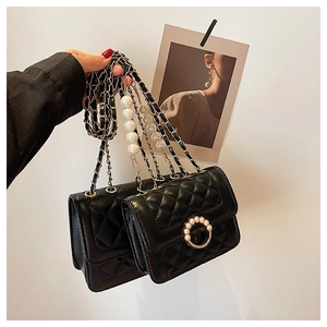 Detail of black quilted PU leather mini bag with pearl lock and chain handle decoration