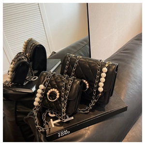 Detail showing two black quilted mini handbags with pearl chain and golden ring buckle