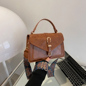 Vintage brown leather crossbody bag with ethnic patterned strap and golden clasp