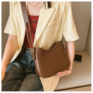Detail of dark brown matte leather hobo bag featuring an adjustable wide shoulder strap