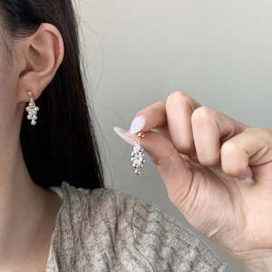Eleganti orecchini a grappolo con sfere d'argento e perni dorati indossati