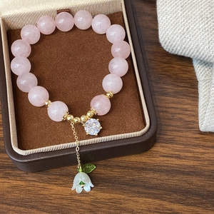 Pink quartz bead bracelet with gold accents, white lily of the valley and zircon pendant