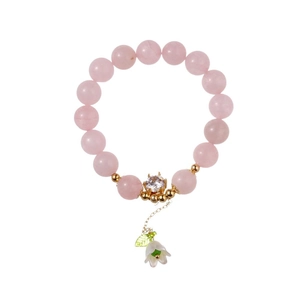 Pink strawberry quartz beaded bracelet with a white shell flower pendant and gold accents