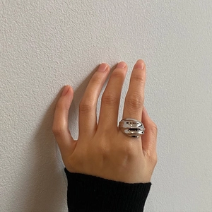 Minimalist silver wavy ring with irregular 3D textured surface worn by a model