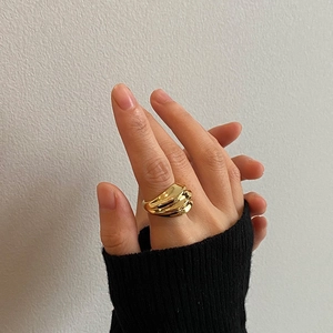 Minimalist gold textured ribbed ring with wave design worn on index finger for daily wear