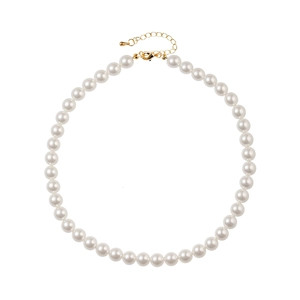 Close-up of white pearls and golden lobster clasp on a minimalist butterfly necklace