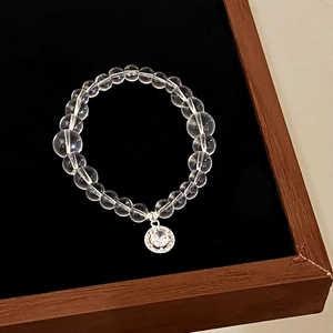 Natural white crystal beaded bracelet with geometric zircon pendant in a jewelry box