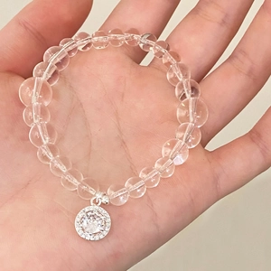 Natural white crystal bead bracelet with geometric zircon pendant shown on hand