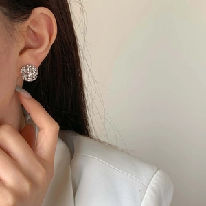 Minimalist silver woven geometric earrings on model for a sophisticated fashion look