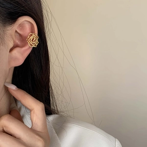 Elegant gold rose ear cuff with 3D textured petals on model without piercings
