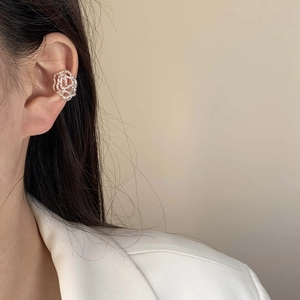 Silver hollow rose ear cuff with irregular texture for non-pierced ears on a model