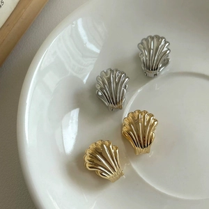 Detail of gold and silver plated scallop earrings with vertical embossed stripes texture