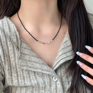 Elegant beaded choker with black beads and silver square accents on a female model