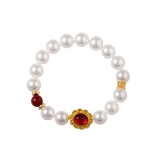 Elegantes Perlenarmband mit rotem Achatanhänger und Goldakzenten auf weißem Grund