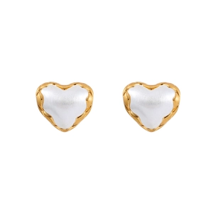 Detail of heart-shaped gold-plated earrings with white inlay and wavy metal edges