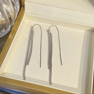 Gros plan de boucles d'oreilles à pampilles argentées étincelantes dans un coffret à bijoux
