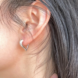Close-up of minimalist heart-shaped earring worn by a model to show design details