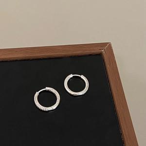 Close-up of silver hoop earrings with shimmering micro-pave cubic zirconia stones