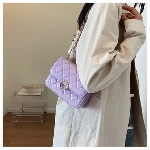 Detail of purple quilted shoulder bag with pearl ring buckle and pearl chain strap