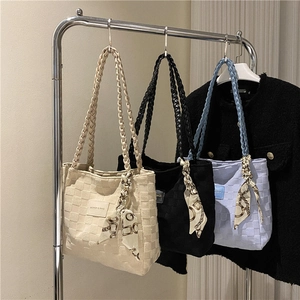 Three oversized woven canvas tote bags in beige, black and blue with decorative silk scarves