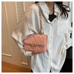 Detail of light pink quilted shoulder bag with pearl ring buckle and leather chain strap