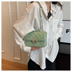 Detailed view of light green quilted shoulder bag with pearl buckle and chain strap