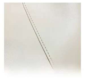 Macro shot showing high-quality stitching and texture on vintage leather bucket bag