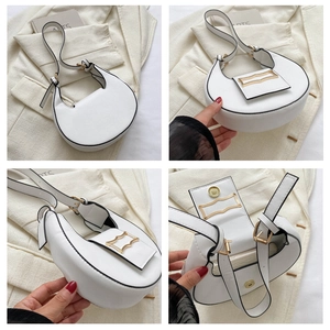 Stylish white crescent underarm shoulder bag with black piping and gold hardware details.