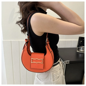 Stylish orange crescent shoulder bag for women, trendy underarm hobo bag with metal clasp.