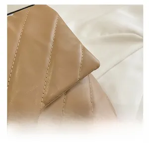 Detailed view of the brown quilted leather texture and fine stitching on the shoulder bag