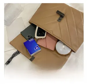 Internal capacity of a quilted crossbody bag showing smartphone, sunglasses, and wallet