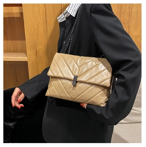 Close-up of khaki quilted faux leather bag with V-shaped stitching and metal chain strap