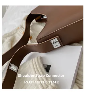 Detail of silver square buckle and brown leather strap on minimalist shoulder bag