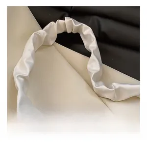 Gros plan sur la bandoulière en satin blanc perle plissé avec texture élégante