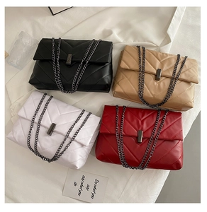 Flat lay of quilted crossbody bags in four colors with metal chain straps and hardware