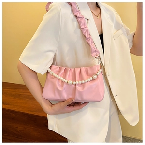 Détail du sac nuage rose plissé avec chaîne en perles et bandoulière souple assortie