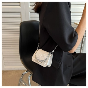 Detail of white mini crossbody bag with 3D floral texture and stylish silver chain strap