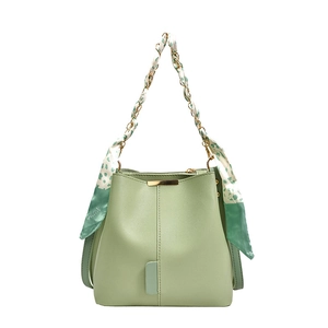 Light green bucket handbag with floral silk scarf on golden chain handle and gold accents
